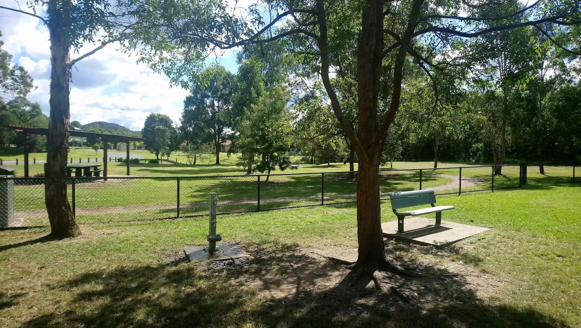 Shaded fenced dog park with water station at an RV campground
